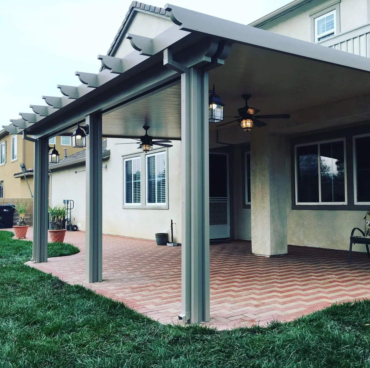 Dark attached patio cover over a brick outdoor room